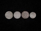 a close up of three silver coins on a black surface