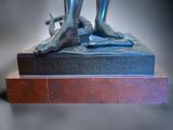 a bronze statue of a person holding a knife