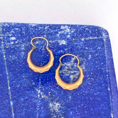 pair of blue and gold earrings on a blue marble slab