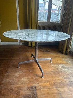 une table au plateau en marbre au milieu d'un parquet