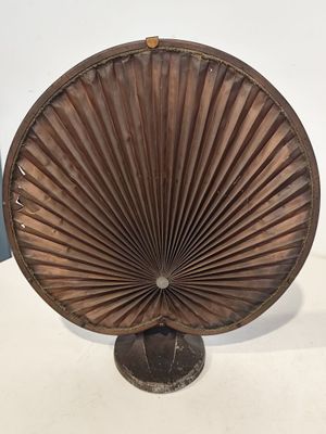 une photo d'un éventail en bois posé sur une table blanche