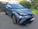 the toyota c - hr is parked on the street in front of a fence
