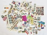 une pile de timbres et de cartes postales posée sur une surface blanche