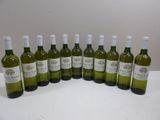 six bottles of white wine are lined up on a table