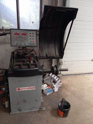 une machine qui se trouve dans un garage, à côté d'une poubelle
