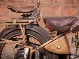 a old motorcycle that is parked in front of a brick wall