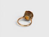 a close up of a gold ring on a white surface