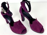 une paire de sandales à talons hauts violettes, ornées d'une boucle métallique à la cheville