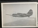 a black and white photo of a plane flying in the sky