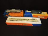 three model trains in boxes on a black surface