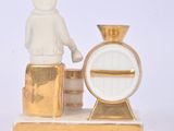 a figurine of a man standing next to a clock