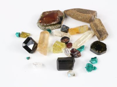 un tas de pierres et de cristaux de différentes couleurs posés sur une surface blanche