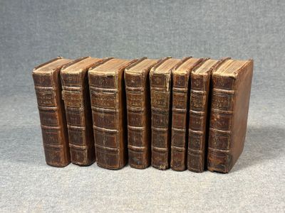 a set of six old books sitting on top of each other