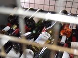 many bottles of wine sitting in a metal basket