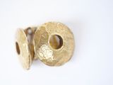 gold plated metal studs with holes on a white surface