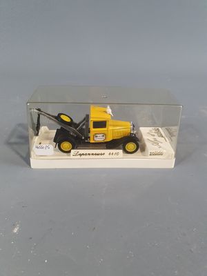a yellow toy truck with a crane in a clear box
