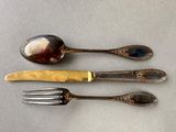 two forks and a spoon sitting next to each other on a table
