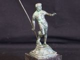 bronze statue of a man holding a spear on a marble base