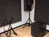 two speakers and a speaker stand in the corner of a room