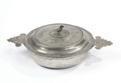 an antique silverplated casserole with a lid on a white background
