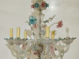 a white chandelier with flowers and candles on it