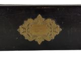 an old black and gold case with a gold design on it