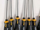 six screwdrivers are lined up in a row on a white surface
