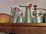 une étagère sur laquelle sont disposées de nombreuses cafetières et théières de différents types