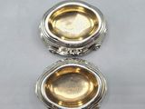 an image of a silver plate with a silver lid on a white surface