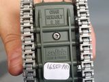 a hand holding a small army green device in it ' s left hand