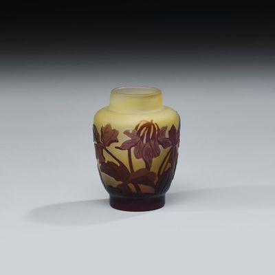 un vase jaune orné de fleurs, posé sur une table