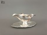 un service en argent ancien composé d'une assiette et d'une soucoupe posée dessus