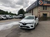 une voiture blanche garée devant un immeuble devant lequel sont garées d'autres voitures