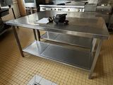une grande table en acier inoxydable au milieu d'une cuisine