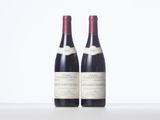 two bottles of wine sitting on top of a white table