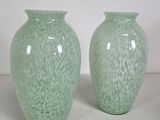 two green vases sitting next to each other on a table