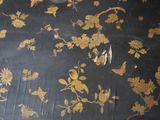 a black table with a gold floral design on it