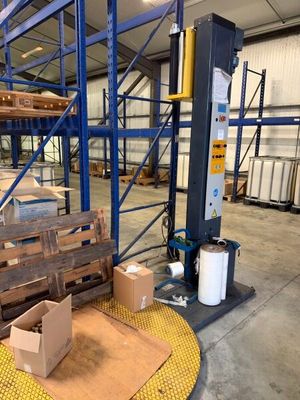 un grand entrepôt avec des palettes et des cartons posés à même le sol