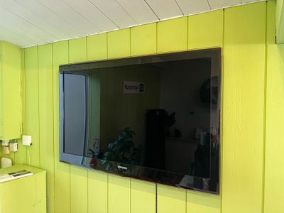 a television mounted on the wall in a yellow room