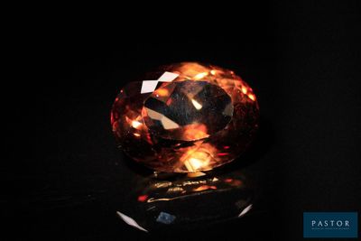 un gros diamant orange sur un fond noir