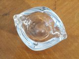 a glass ashtray sitting on a wooden table
