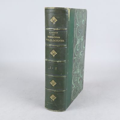 un livre vert posé sur une table blanche