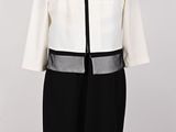 a white and black dress with a black belt on a mannequin