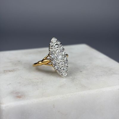un gros plan d'une bague en or sertie de diamants blancs posée sur un bloc de marbre