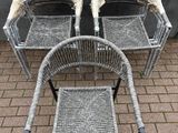 deux chaises et une table sur une terrasse en briques, à côté d'une jardinière