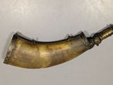 an old brass pipe with a black handle on a white surface