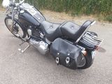 a black motorcycle parked in a parking lot next to a hedge