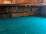 a green carpeted floor with a wooden chest of drawers