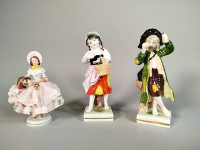 trois figurines en porcelaine représentant des enfants vêtus de costumes d'époque
