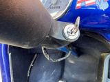 a close up of a blue motorcycle with a black handlebar